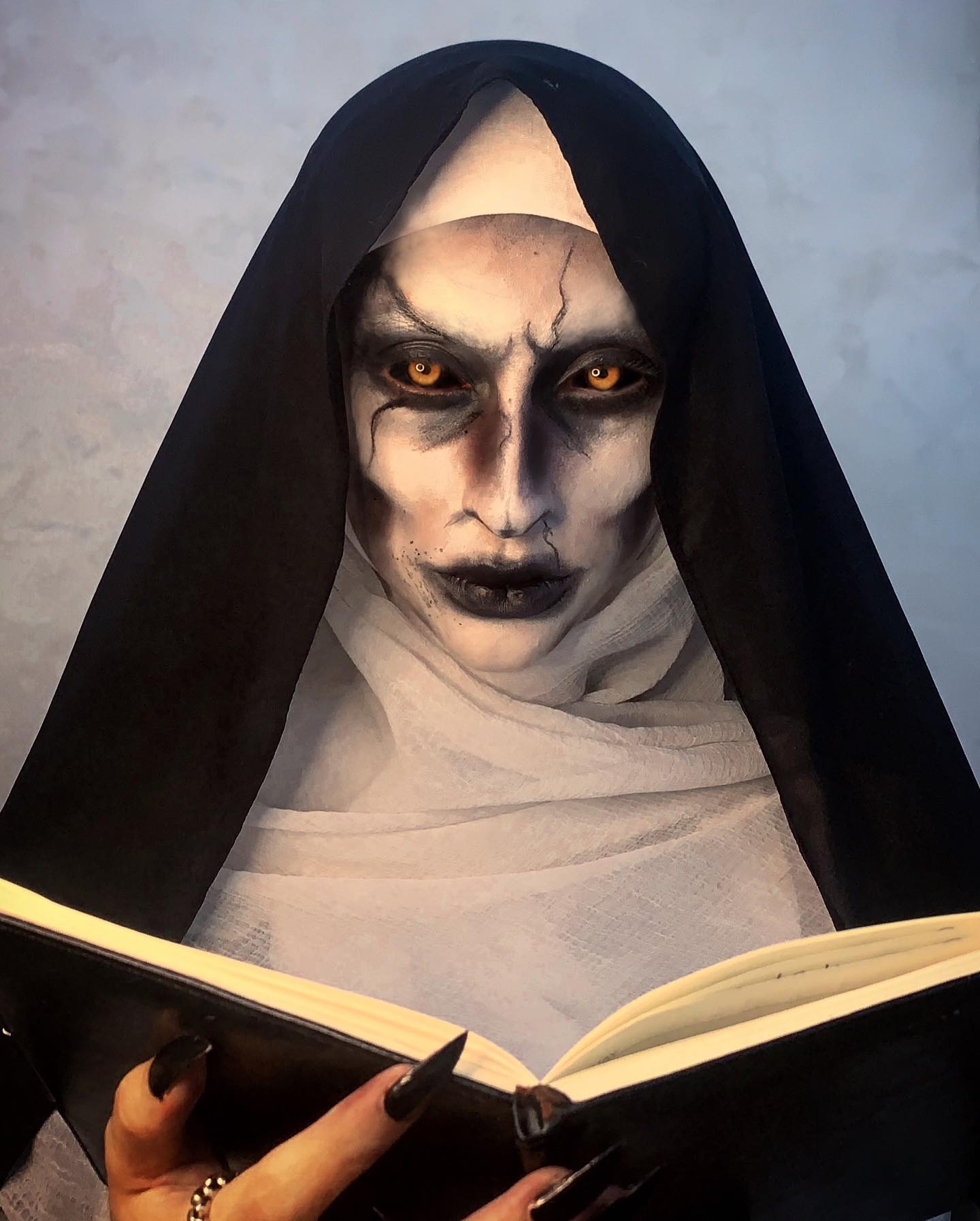 Horror character study of a demon nun with a white coif and glowing eyes