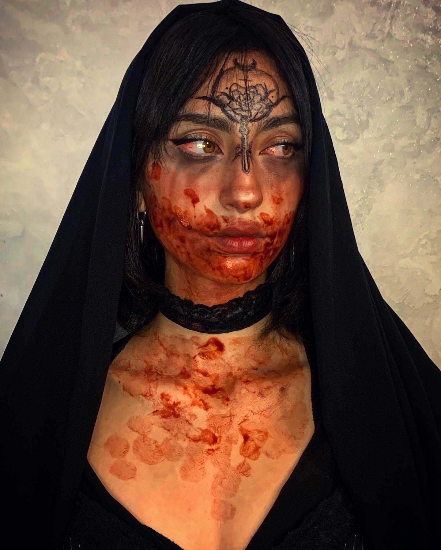 Special-effects possession makeup with a black veil, sigil and blood